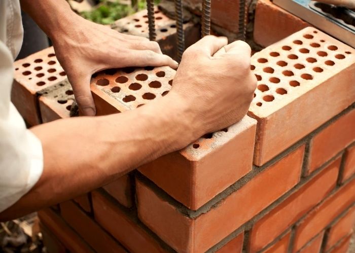 A picture of someone building a hard brick wall