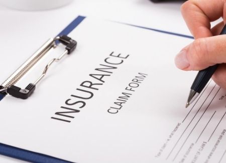 An image of someone filling out an insurance claim form 