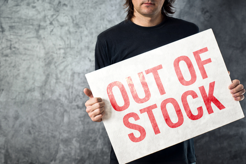 man holding a sign saying out of stock