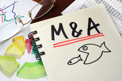 letters M & A on notepad with drawing underneath of big fish eating little fish